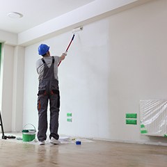 Man painting a wall; commercial painting in Plano, TX