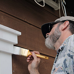 Man painting exterior house trim