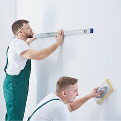 Two men prepping walls for paint