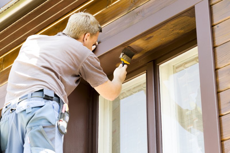 man painting exterior of home