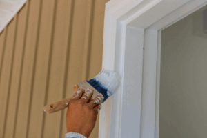 a person preparing to paint their home’s exterior